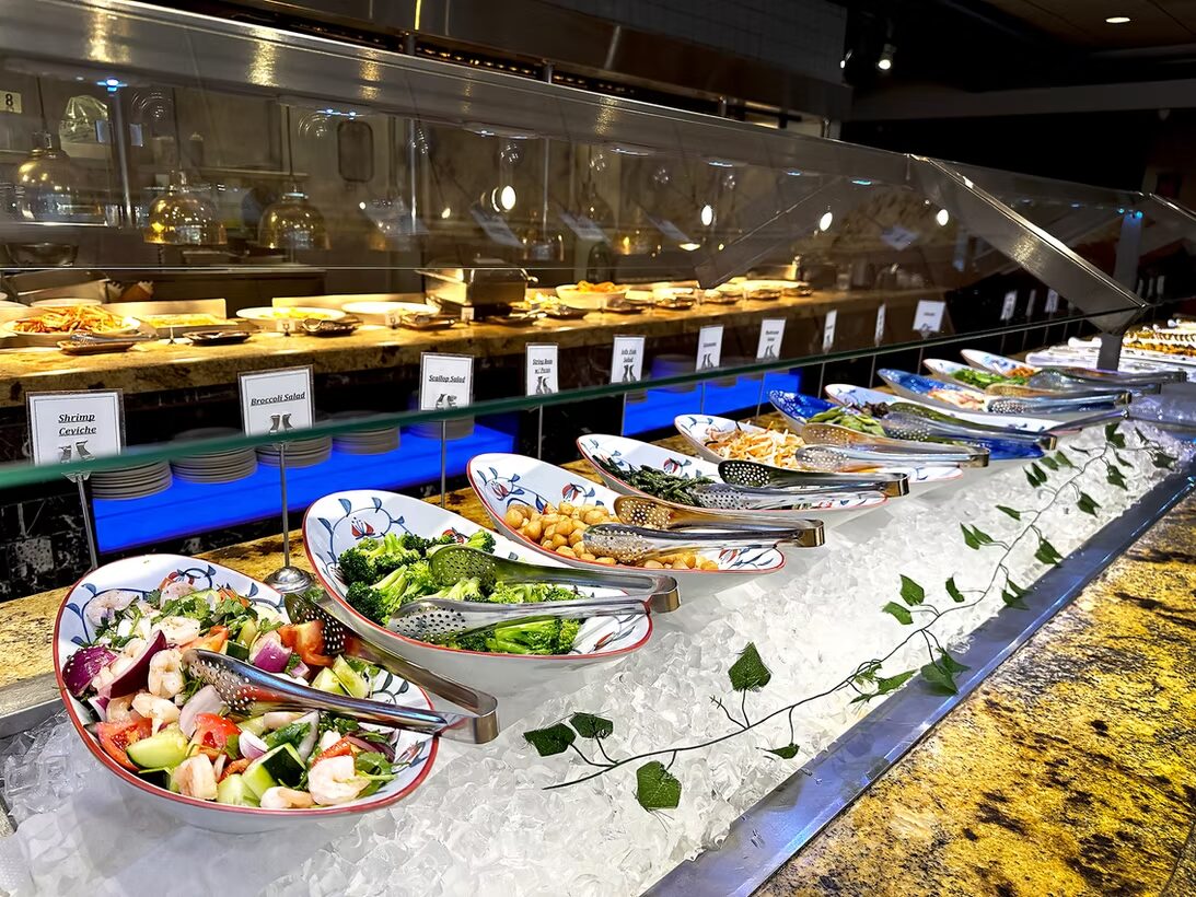 Salad bar line with labeled dishes on ice